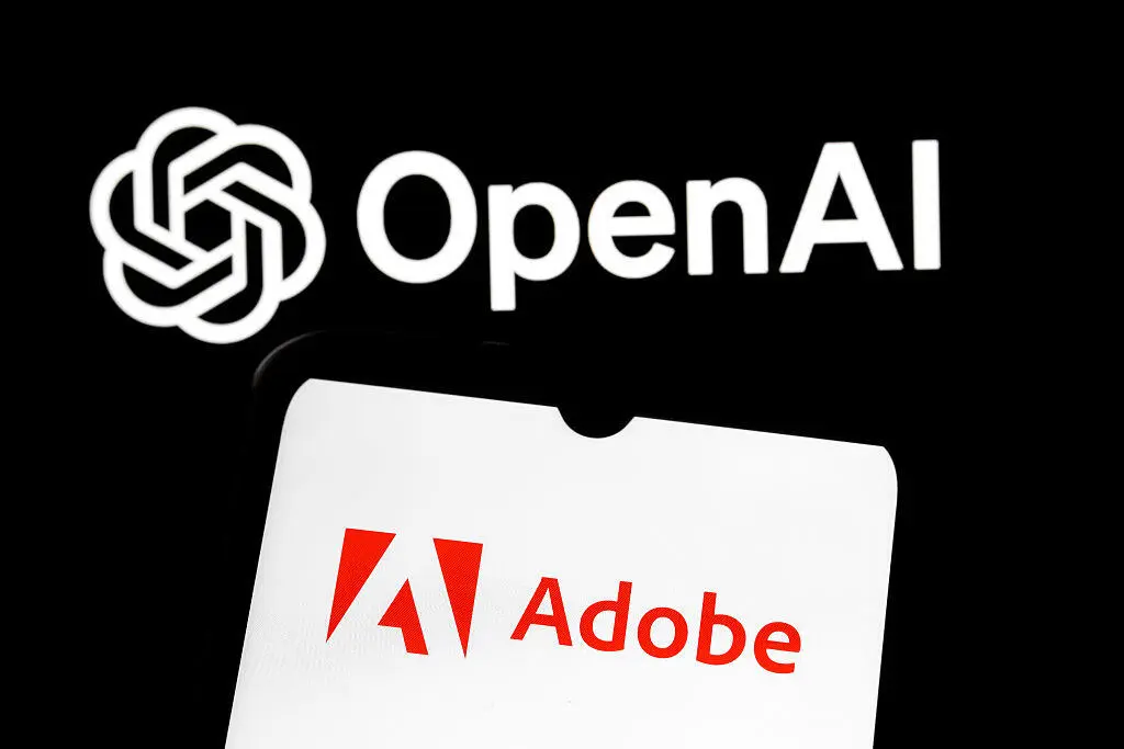 Photo and Video Editing in ChatGPT Just Got an Adobe-Size Update Adobe logo on smartphone in front of background with OpenAI logo