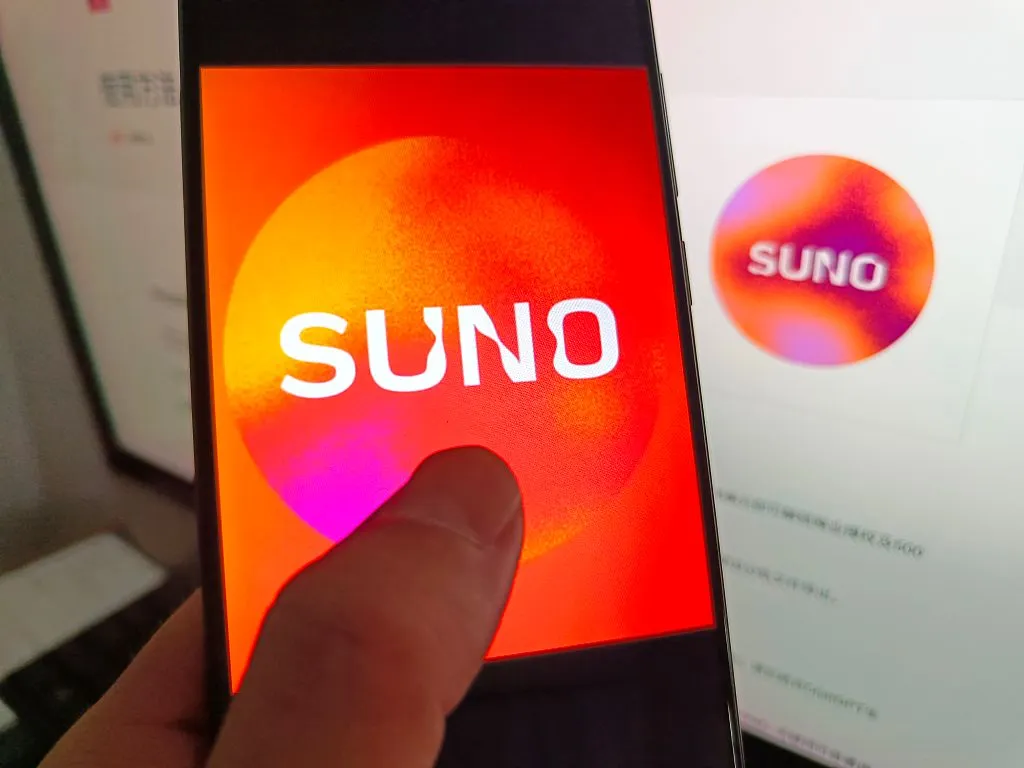 Suno Plans New Tools to Make AI-Generated Music More Transparent. Is It Enough? Suno's logo on a smartphone with Suno's logo in the background.