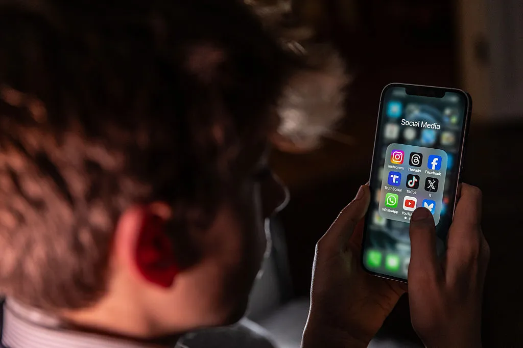 What Meta’s All-New Social Media Guidelines Promise to Change for Teen Users Teen looking at social apps on phone.