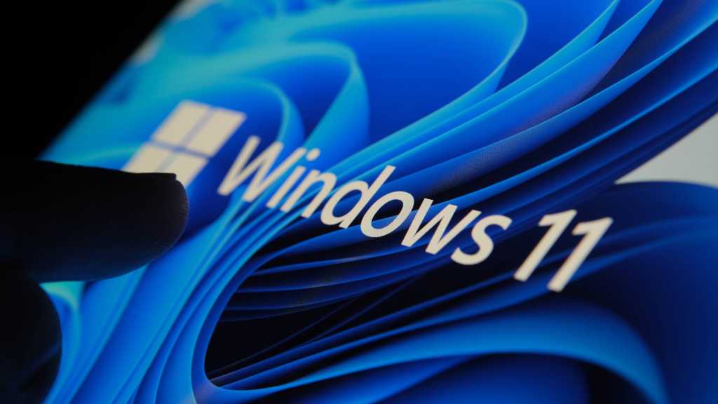 Windows 11’s optional August update has a cursor bug. Skip it for now Finger touching Windows 11 logo on screen in dark room