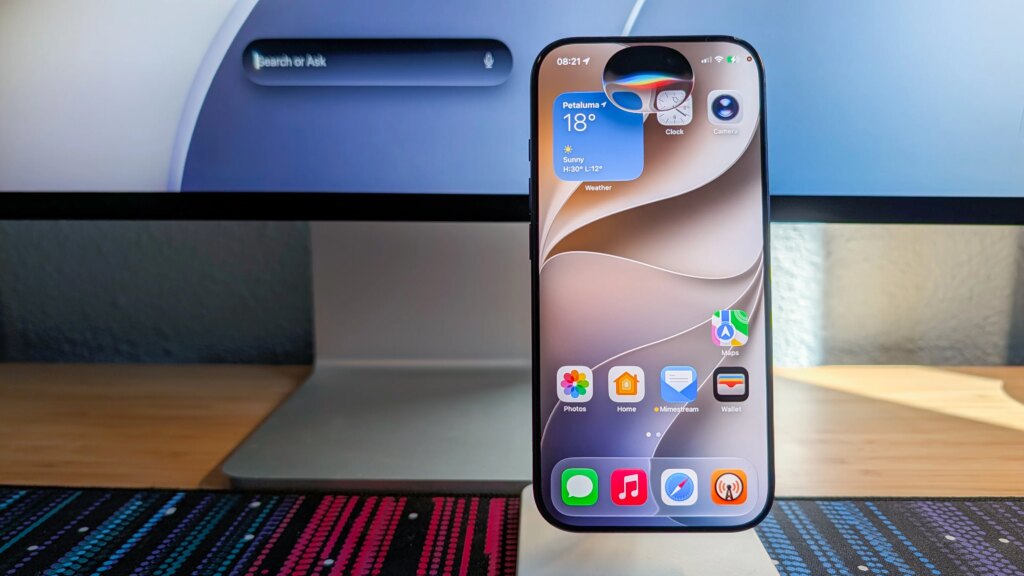 Apples neuer Assistent in iOS 27 im Realitätscheck Neue Siri-Oberfläche auf einem iPhone vor einem Mac mit schwebendem Siri-Suchfeld