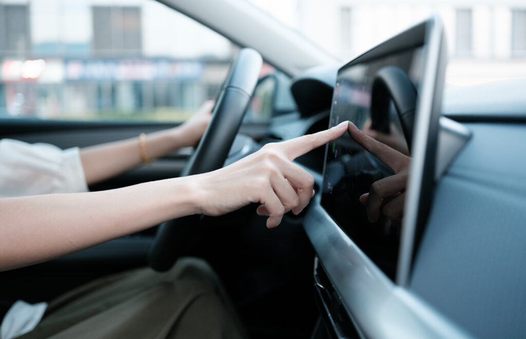 Automakers Want Congress to Ban Chinese-Made Cars, Citing Data Privacy Driver is tapping car screen.