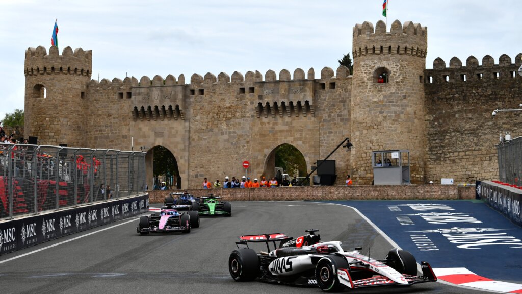 Azerbaijan Grand Prix: How to Watch the F1 Race Today F1 cars driving around the Baku Street Circuit with the Maiden Tower in the background.