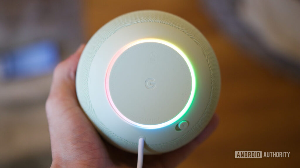 Google Home Speaker with its ring light on.