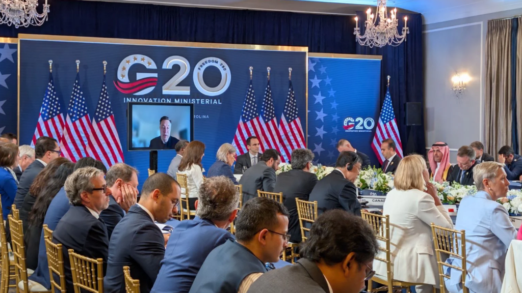 Leaders seated at a long table in front of the G20 logo