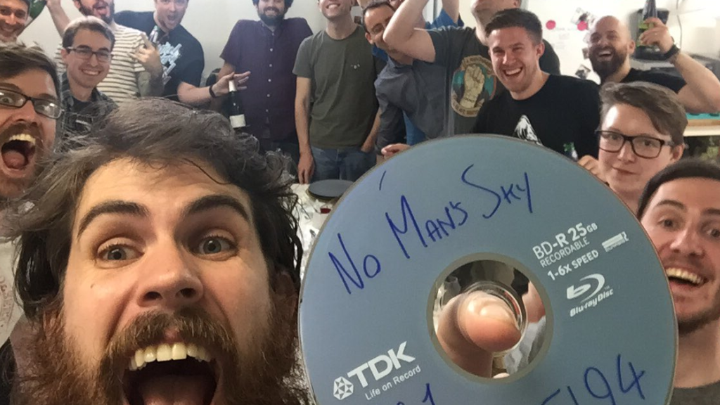 Sean Murray holding up a disc labeled "No Man's Sky" on the day it went gold in 2016.