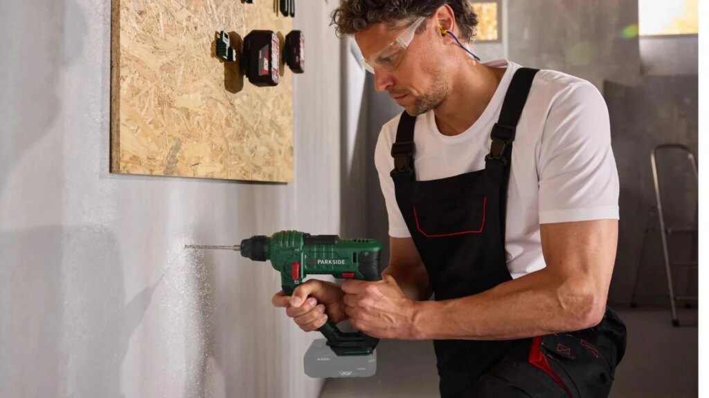 Ein Mann bohrt mit einem Parkside Akku-Bohrhammer