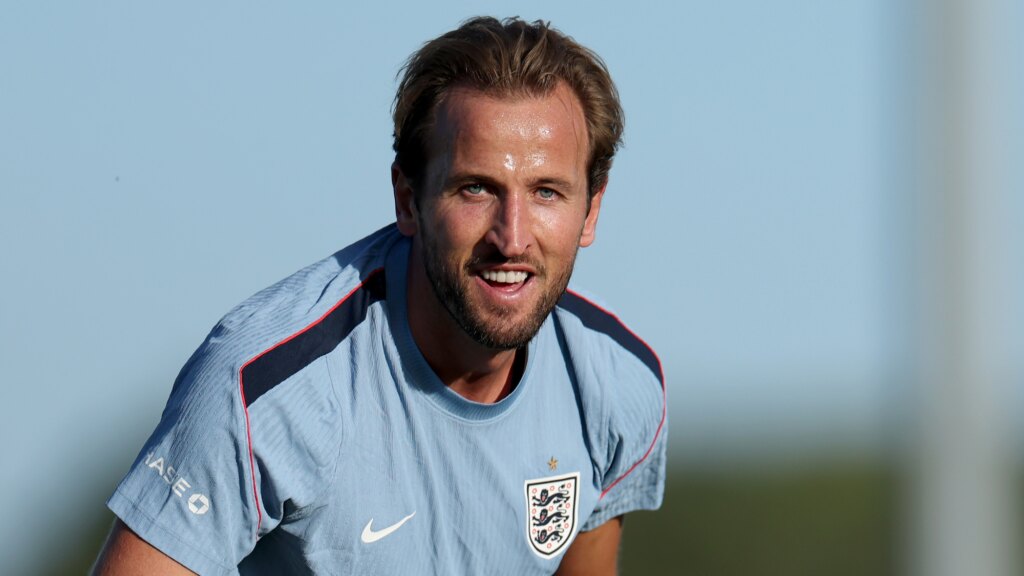 England captain Harry Kane leaning forwards, smiling.