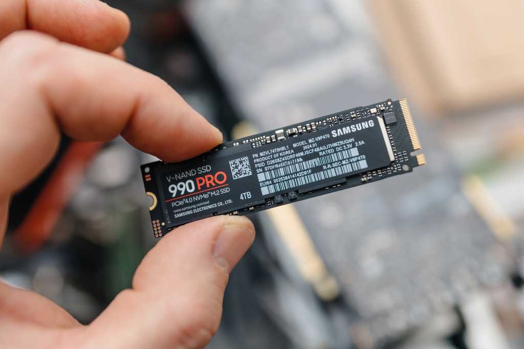 How much SSD space do you really need? The PC buyer’s guide to storage Man holding Samsung 990 PRO SSD between fingers over exposed laptop hero