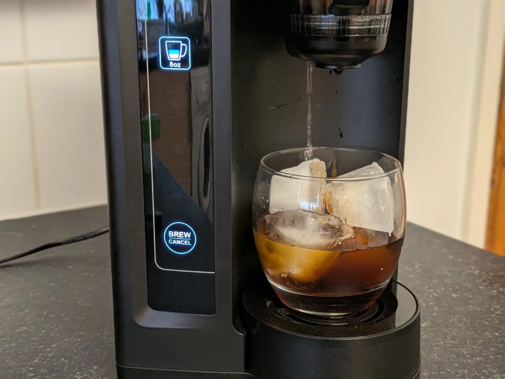 The Cuisinart Concentra Is a Dream Come True for Cold Brew Drinkers concentra dispensing cold brew into glass of ice